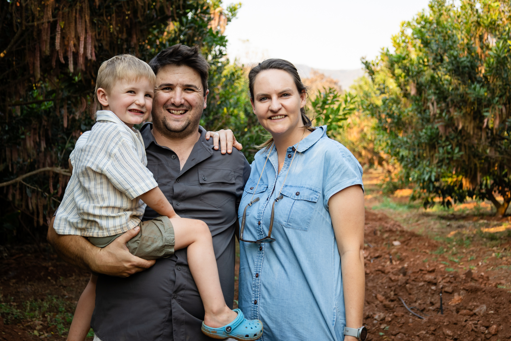 Amy, Tyler, and Callum among the macadamias at Romelda
